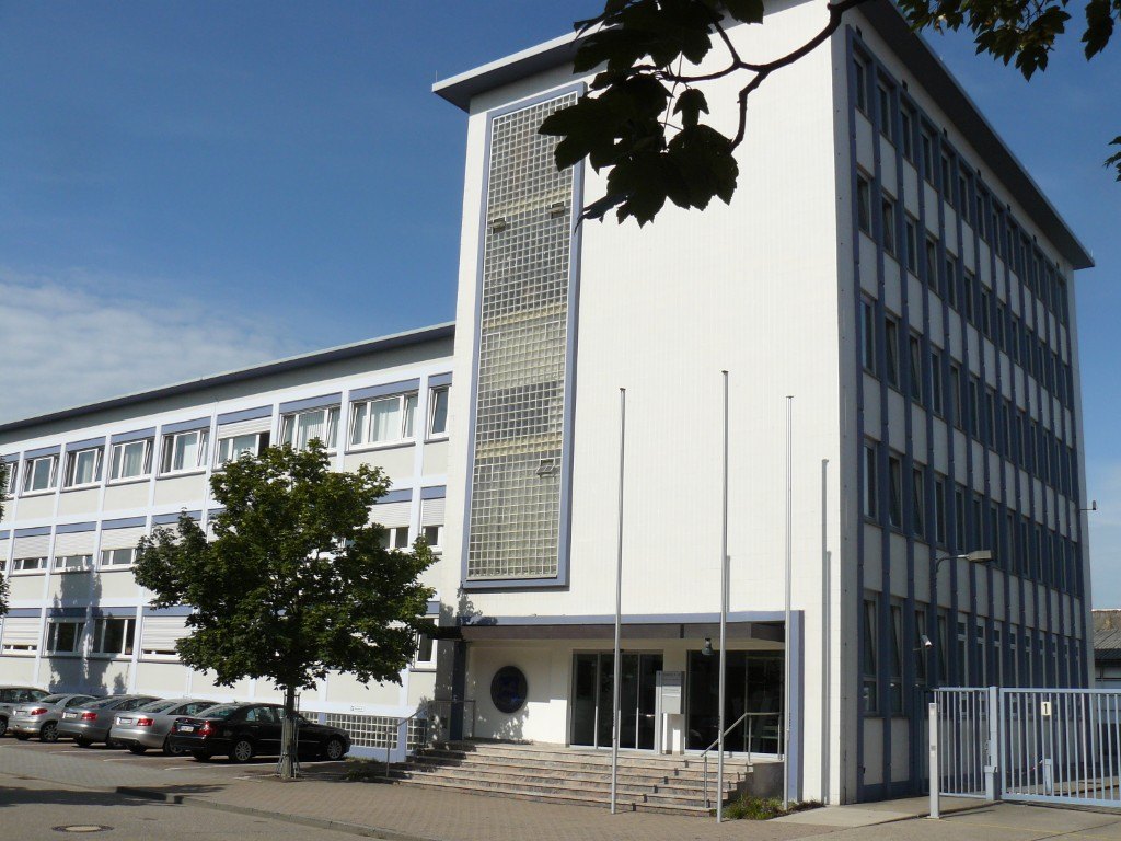 Fassade des Firmengebäudes mit Eingang und Vorplatz