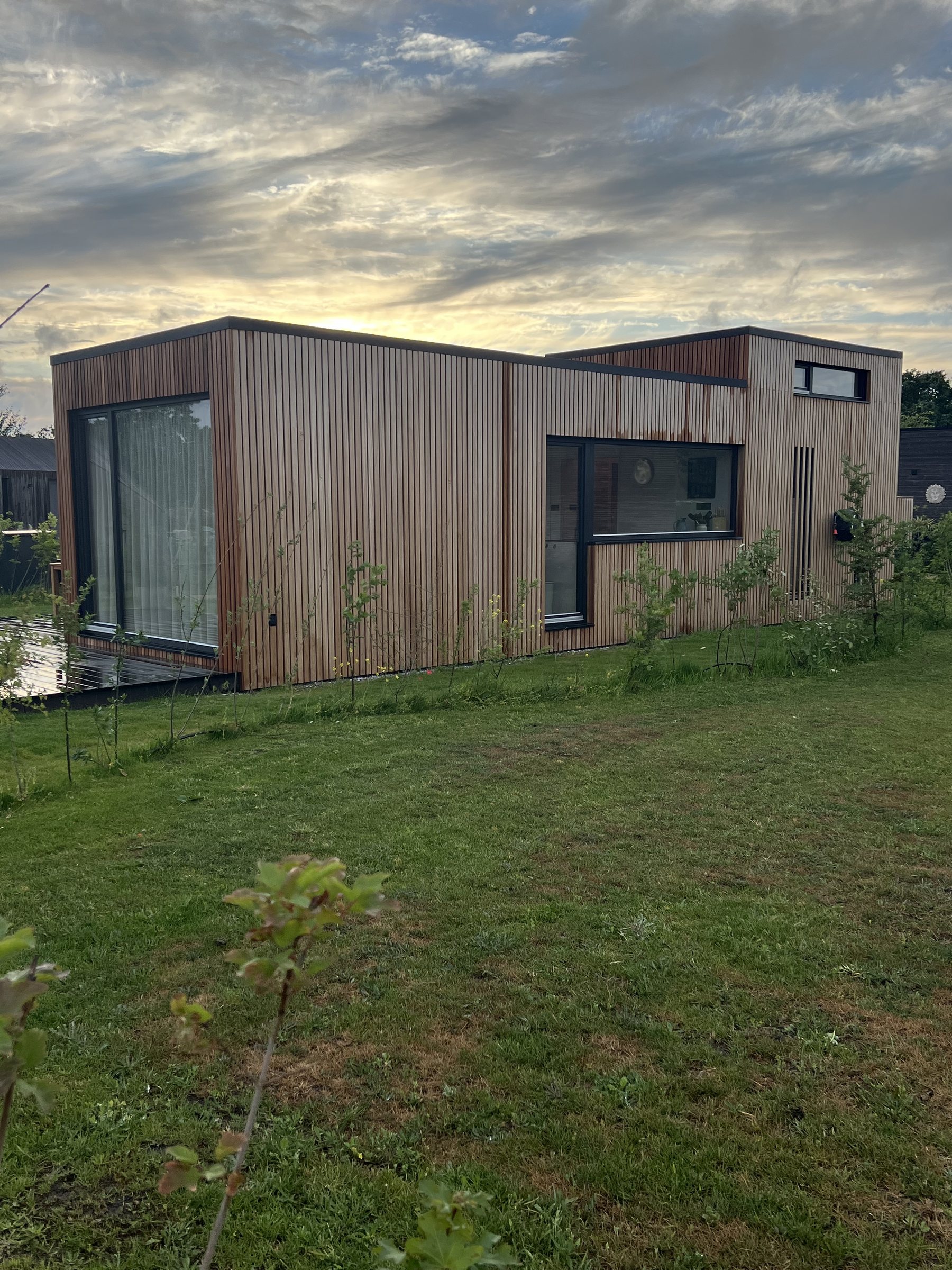 Holzfassade des Tiny House an der Küchenseite mit langem Küchenfenster