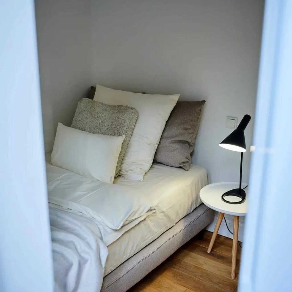 Bett mit weißen Kissen und Leseleuchte