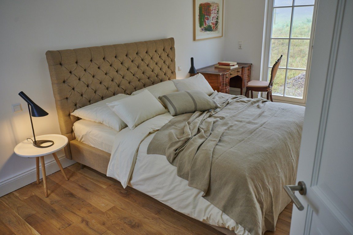 Schlafzimmer mit gepolstertem Kopfteil in Sandtönen